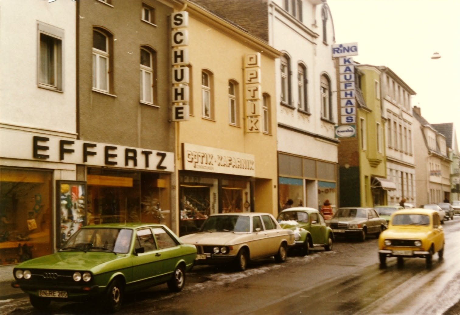 Geschäftsstraße in Bonn-Duisdorf in den siebziger Jahren mit Autos und Schneeresten