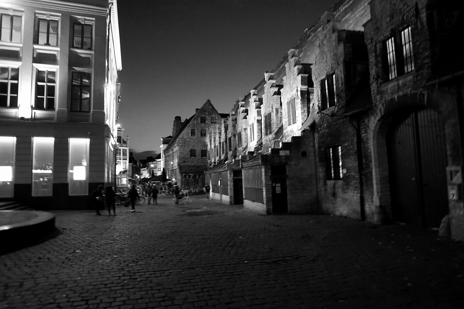 Nächtliche Schwarzweißfotografie einer Genter Gasse zwischen historischen Gebäuden