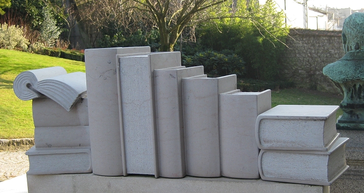 Steinerne Bücher als Skulptur in einem Garten