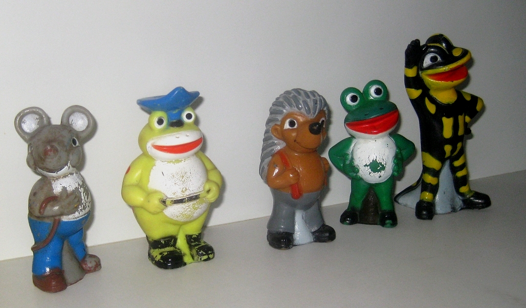 Abgenutzte bunte Tier- und Comicfiguren stehen in einer Reihe